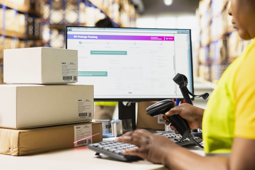 Warehouse worker using barcode scanner to process delivery packages