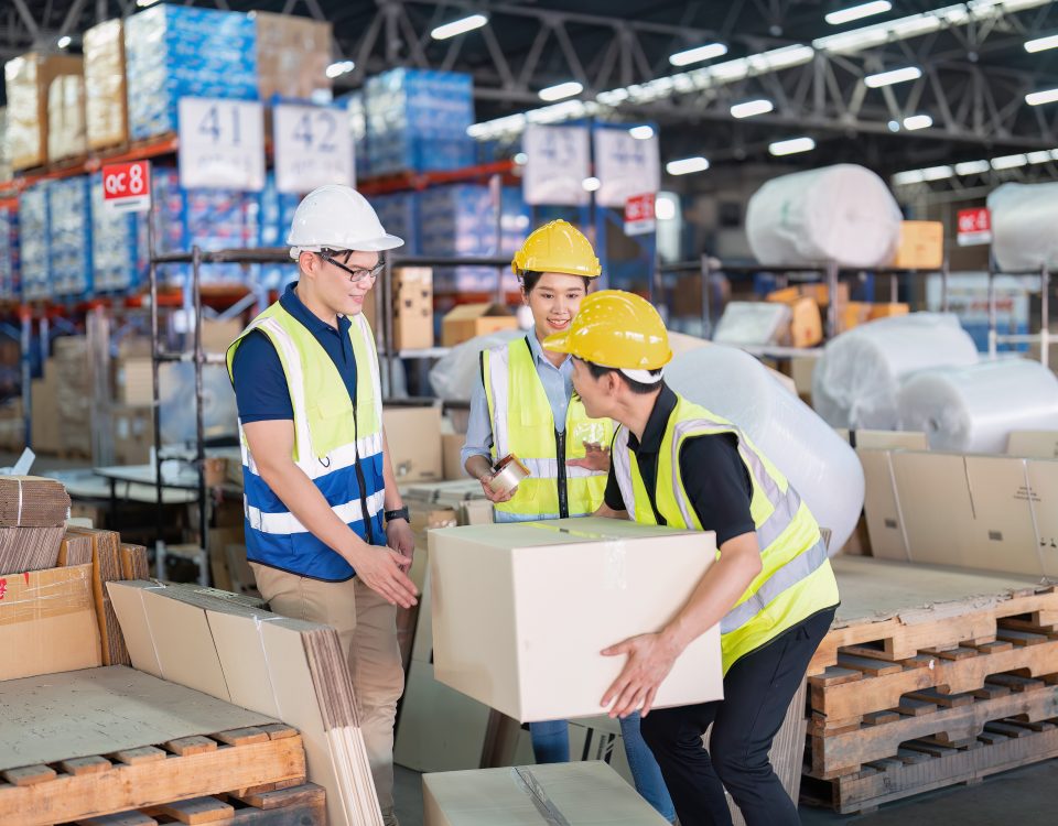 Logistics team packing and moving boxes inside a warehouse